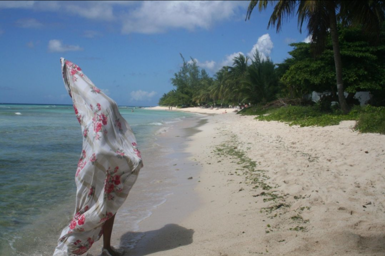 Woman on a beach covered in a floral sheet